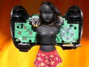 a black doll embedded into a game pad as if it is wings.