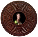 Portrait photograph in a heavy round wooden frame. A woman in a green silk Renaissance dress looks down and to her right. 